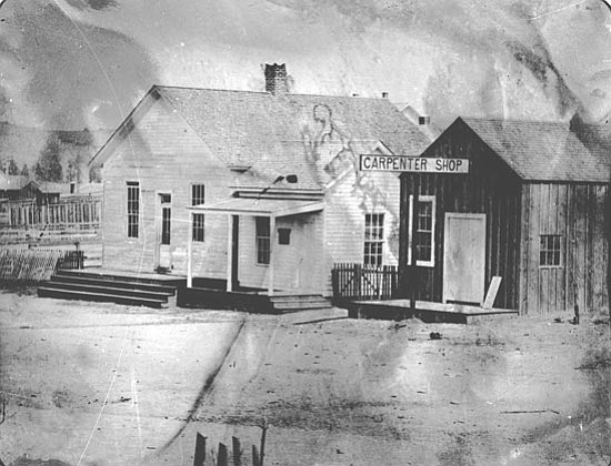 The Prescott School House, left of the carpenter shop, was converted into the community reading room after the 
completion of the Prescott 
Free Academy in 1877.