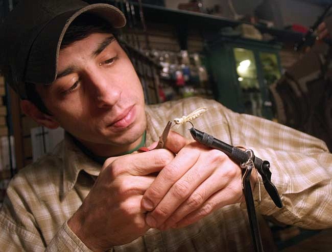 Jason Meszaros of Lynx Creek Unlimited trims one of his handmade flies at the store in the Bashford Court on Gurley Street in downtown Prescott.

The Daily Courier/
Les Stukenberg