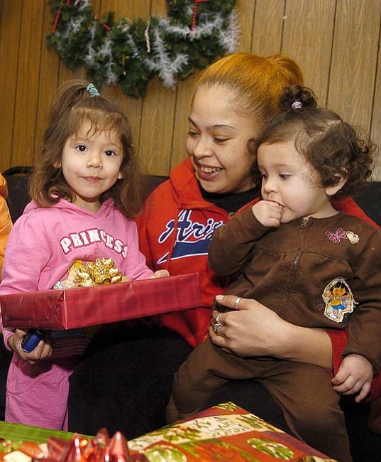 Mary Vasquez and two of her daughters, Maryjane Miranda, 2, and Sarita Miranda, 1, browse through some Christmas presents that they received from Brenda O’Hara, a board member from the Tri-City Hispanic chamber of Commerce, on Friday afternoon in Prescott.  

The Daily Courier/Matt Hinshaw