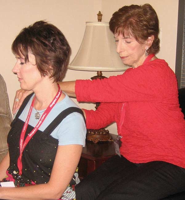 The Daily Courier/Lorin McLain<br>
Carol Ann Kearns applies Reiki massage to hospice councilor Tara Tyler, who is experiencing an aggravated reaction to a recent flu shot.