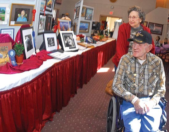 The Daily Courier/Matt Hinshaw<br>
Alick Sowers, US Army Retired, and his friend Marianna Hobbs look at artwork during the 15th annual Veterans Creative Arts Show at the Bob Stump VA Medical Center in Prescott on Monday afternoon.