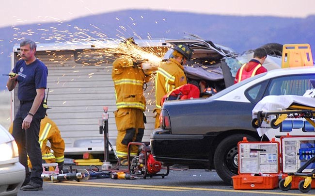 The Daily Courier/Matt Hinshaw
<br>
Central Yavapai Fire District emergency workers use a saw to extricate victims from one of the vehicles involved in a collision on Fain Road north of Highway 69 Monday evening.  
