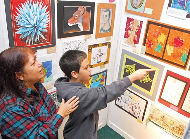 The Daily Courier/Matt Hinshaw<br>
Nick Redmond, 14, and his mother Linda Garlinghouse talk about some of the artwork at the PUSD Youth Art Month Display at Yavapai College Monday afternoon in Prescott.