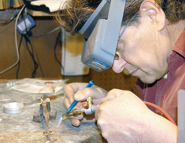 The Daily Courier/Jason Soifer<br>
Fred Tenca does some soldering at his desk in the Kikkapoo Express Indian Jewelry store on Whiskey Row.