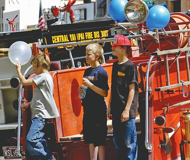 The Daily Courier/Jo. L. Keener<br> 
Jared Lam, Nick Buell and Albert Lam pose for a photograph on the back of an older fire engine Saturday during the annual Wildfire Expo next to the courthouse in downtown Prescott.