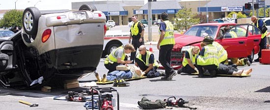 The Daily Courier/Les Stukenberg<p>
Emergency personnel treat the victims of a two-vehicle collision in the intersection of Robert Road and Highway 69 in Prescott Valley Wednesday afternoon.
