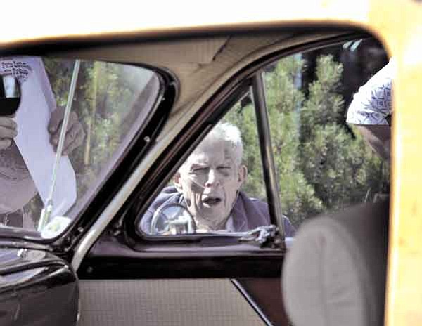 Jo. L. Keener/The Daily Courier<br>
Harold Wolfinger peers through the window vent of a 1951 Ford Woody Friday morning. Prescott Antique Auto Club brought a number of restored vintage cars for residents of Las Fuentes Assisted Living Center to see.