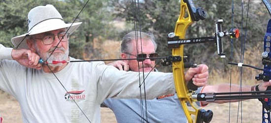 Les Stukenberg/<br>The Daily Courier<br>“The good archer can stand at one end of a football field and shoot an arrow 100 yards into a grapefruit at the other end,” says Bob Park of Prescott, 80, left. He and John Nay of Prescott Valley, 65, practice at the Granite Mountain Archery Range in Prescott.
