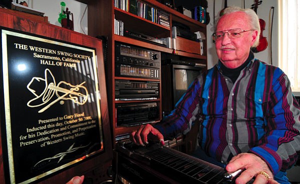 Les Stukenberg/The Daily Courier<br>
Gary Hood plays the steel guitar in his Prescott Valley home after the Western Swing Society recently inducted him into its Hall of Fame in Sacramento, Calif.