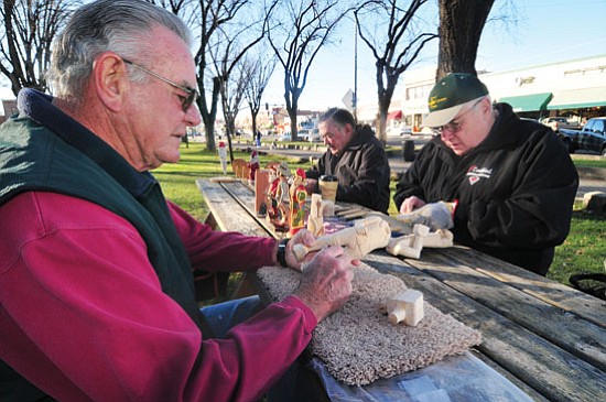 Les Stukenberg/The Daily Courier<br>
Woodcarvers, from left, Bill Holmes, Jerry Goar and Jim Walton work on some of their figures Friday morning on the courthouse plaza. The men, all members of the Prescott Wood Bee Carvers Club, gather every Friday from 9 ’til noon depending on the weather on the west side of the plaza.