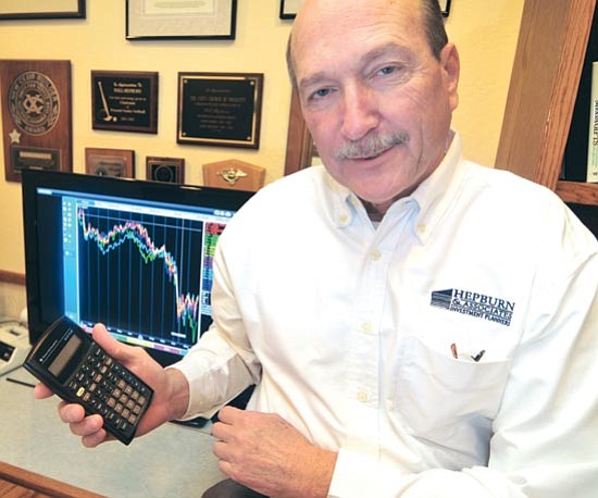 Will Hepburn shows off his main investment tool - the calculator. 

Les Stukenberg/The Daily Courier

