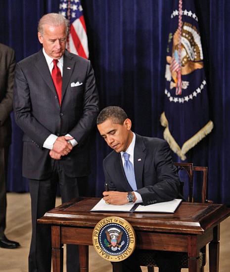Ron Edmonds/The Associated Press<p>
Vice President Joe Biden looks on as President Barack Obama signs executive orders Wednesday in the Eisenhower Executive Office Building in Washington.
