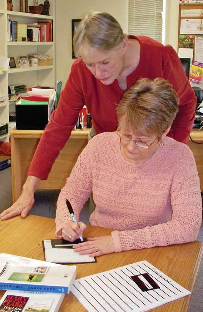 Courtesy photo
Jan Johnson, occupational therapist and course coordinator, observes Nancy Reynolds, program manager of People Who Care, as she follows instructions on how to use a template to write a check.