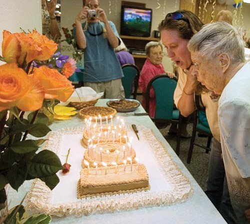 Matt Hinshaw/The Daily Courier<br>
Frances Rose and her granddaughter, Carrie Vickerman, work together to blow out the candles on Rose’s 100th birthday cake Thursday afternoon at the Prescott Samaritan Village.
