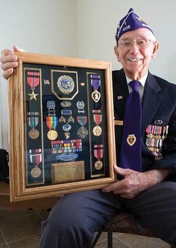 Matt Hinshaw/The Daily Courier<p>
D-Day veteran Lewis Burns holds up a case that displays several of the medals he earned during World War II. Burns was a member of the 501st Parachute Infantry Regiment that dropped into Normandy, France, the night before the D-Day invasion.