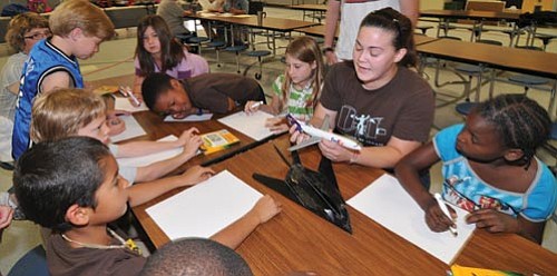 Les Stukenberg/The Daily Courier<br>
Embry-Riddle Space Physics senior Candice Brown shows children in the PUSD Kids & Co. summer program a plane as they drawn their own aircraft on Wednesday.