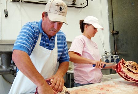 Ken Hedler/The Daily Courier<p>
Wade Caslin, owner of Wade's Custom Meats in Chino Valley, and his daughter, Chelsie Schuster, cut meat Tuesday morning.
