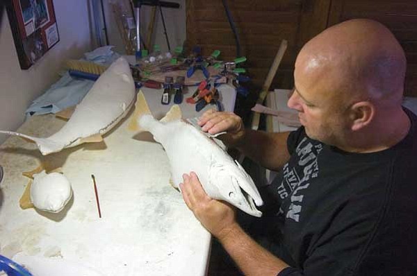 Matt Hinshaw/The Daily Courier<br>
Kerby Ross sands a fish replica at his home in Chino Valley.