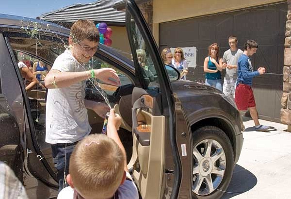 Matt Hinshaw/The Daily Courier<br>
Bring Tipton, 6, sprays his older brother Jonathan, 15, with Silly String Saturday afternoon in Prescott. The Make-A-Wish Foundation granted Jonathan's wish and a crowd of friends and family surprised him Saturday. His wish was to make his own home movies.