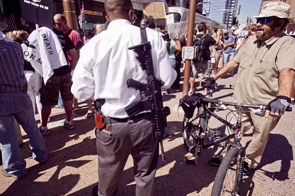 Jack Kurtz, The Arizona Republic/The Associated Press<br>
A man who supports the U.S. Constitution's Second Amendment right to keep and bear arms carries a military style AR-15 type rifle during an Obama opposition rally in Phoenix on Monday. The rifle's clip is in his back pocket.