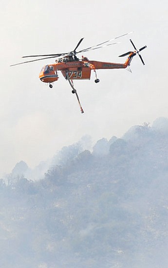 Les Stukenberg/The Daily Courier<p>
Heavy helicopter 734 flew through the smoke on its way to get more water to the Woodchute Fire near the top of Mingus Mountain Aug. 10.