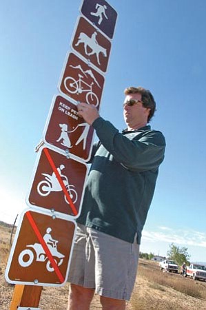 The Daily Courier/file<p>
Chris Hosking, trails specialist with the City of Prescott, installs signs at the Peavine Trail Side Road Trailhead in Prescott in October 2007.




