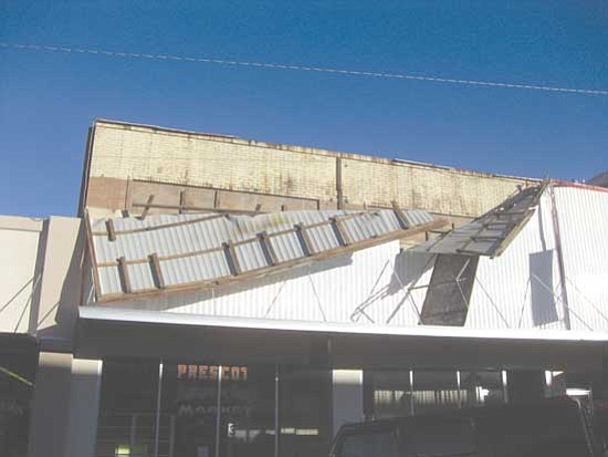 Bill Otwell/<br>Courtesy photo<br>Winds from Monday night's storm tore a portion of the aluminum siding from the front of the vacant Prescott Antique & Craft Market on Cortez Street.
