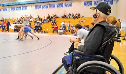 John McCraw, a former wrestler, watches a Chino Valley High School wrestling match Wednesday afternoon in Chino Valley. The Cougars fulfilled his dream by making him an honorary team captain. McGraw has not attended a wrestling match in 44 years. Matt Hinshaw/The Daily Courier