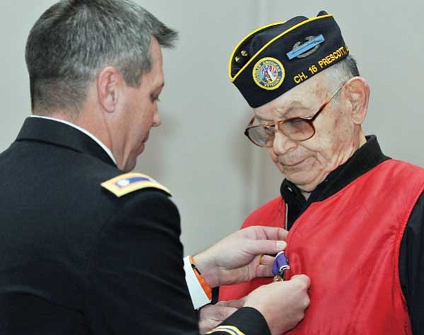 Les Stukenberg/The Daily Courier<br>
Lt Col. Jim Adams pins the Purple Heart on World War II veteran Norman D. Fellman of Prescott, one of the former Berga soldiers, at a ceremony at the Prescott VA Hospital on Wednesday.