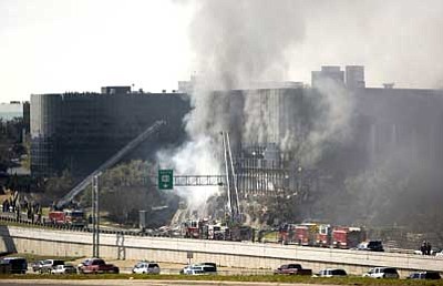 Jay Janner/Austin American-Statesman, AP<br>Smoke billows from a seven-story building as firefighters scramble to put out the fire after a small private plane crashed into the building in Austin, Texas on Thursday.<br/>