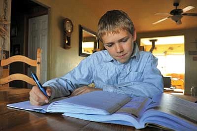 Matt Hinshaw/The Daily Courier<br/>Ryan Rozendaal works on some schoolwork at his home in Prescott Valley Saturday afternoon.  Rozendaal recently won a statewide poetry contest for home-schooled students and will read his poem during Home School Day at the state Capitol in Phoenix.