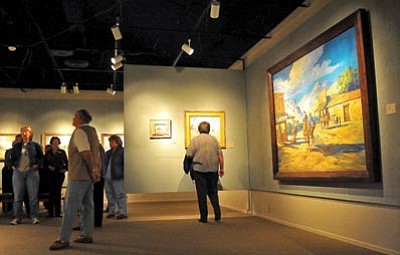Matt Hinshaw/The Daily Courier<br/>Volunteers and docents stroll through the Phippen Museum Friday morning examining the artwork of Marjorie Reed.