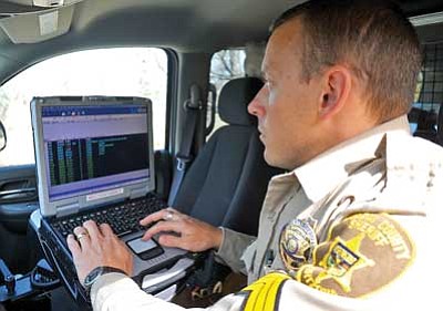Matt Hinshaw/The Daily Courier<br />Yavapai County Sheriff's Department Sergeant Nate Auvenshine demonstrates the departments new mobile laptop system in his patrol vehicle Wednesday afternoon in Chino Valley.  The new mobile laptop system uses cell phone technology which will get better reach than what current patrol vehicle radio systems currently offer.<br />