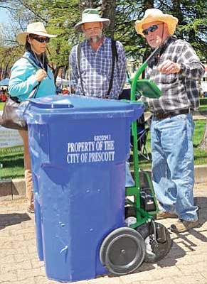 Matt Hinshaw/The Daily Courier<br>Robert Balzano, President of Solar Assist, LLC demonstrates the Solar Porter a solar powered dolly and trash can mover, for Jeff and Lynn Schwartz Saturday morning during the annual Earth Day event at the Courthouse Plaza.