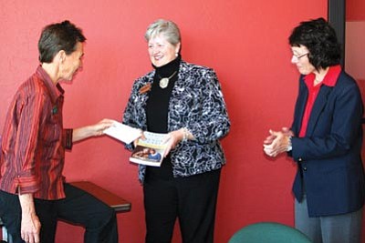 Courtesy photo<br>
Accepting the $1,000 check from Susan Abbott are library director Toni Kaus and Friends of the Prescott Public Library board member Marjory Sente.
