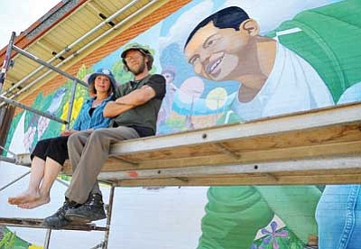 Matt Hinshaw/The Daily Courier <br>Mural Mice Pamela J. Smith, co-artist, and R.E. Wall, co-artist and project director, sit on the scaffolding in front of the Miller Valley School mural titled “ Go on Green” Wednesday afternoon in Prescott. In the next few days the artists will be making adjustments to the new mural.