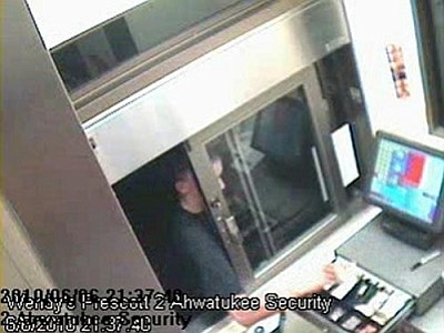 Prescott Valley Police Department/Courtesy<br>
A surveillance camera shows a suspect reaching in the Prescott Valley Wendy’s drive-through window to take money from the cash register.