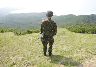 Ahn Young-joon/The Associated Press<br>
A South Korean Marine looks at the North Korean side as he stands guard on Baengnyeong Island, South Korea, near the border with North Korea, June 15.
