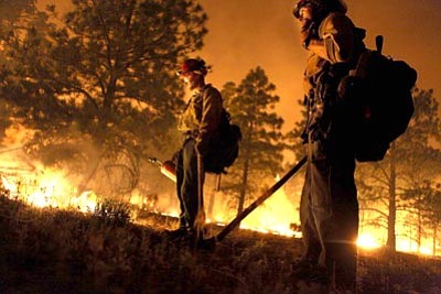 Jake Bacon/The Associated Press<br>
Tyler Jones and Adam Hernandez with the Kings River Hotshot crew work on a back-burn section of the Schultz Fire June 21. The aim of the back-burns is to control the spread of fire by robbing it of fuel.