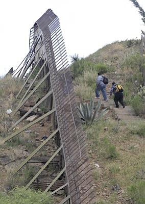 Matt York/The Associated Press<br>In this April 22 file photo, people walk along the international border in Nogales, Sonora, Mexico as seen from Nogales, Ariz.