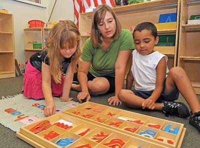 Matt Hinshaw/The Daily Courier<br>
Aly McMillan, director and lead teacher, works with Aspyn Glau, 5, and Jaimin Fowler, 5, on a spelling exercise at the Cedar Tree Montessori Preschool in Prescott.