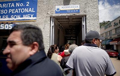 Jae C. Hong/The Associated Press<br>People wait in line to enter the United States in Nogales, Sonora, Mexico, in this July 28, 2010 file photo.