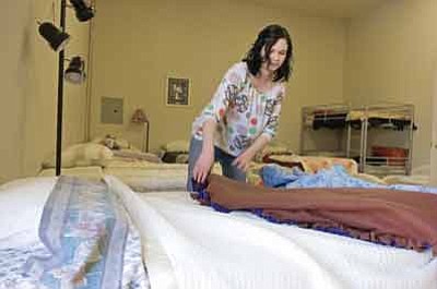 Matt Hinshaw/The Daily Courier<br>In this file photo from March 18, 2009, Erika Stone the Program and Outreach Coordinator makes one of the fifteen beds at the Prescott Area Women's Shelter Wednesday morning in Prescott.