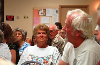 Joanna Dodder/The Daily Courier<br>
Sierra Club leader Jim Vaaler, foreground at right, draws mixed reactions at a Cordes Junction meeting Wednesday night as he speaks against people driving vehicles up and down the Agua Fria River in the Agua Fria National Monument.



