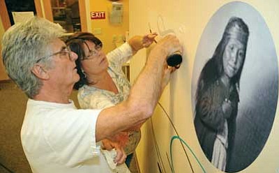Brett Soldwedel/The Daily Courier<br>Kiwi Sign Design’s Gunter and Michelle Haupt put up decorations and pictures of Viola Jimulla last Friday for Monday’s Viola Jimulla Meals on Wheels dedication in the Rowle P. Simmons Community Center.
