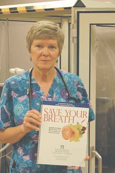 Ken Hedler/The Daily Courier<br>Elizabeth Page, a respiratory therapist at Yavapai Regional Medical Center in Prescott, displays a copy of a spiral-bound book that she wrote for people who suffer from chronic obstructive pulmonary disease.