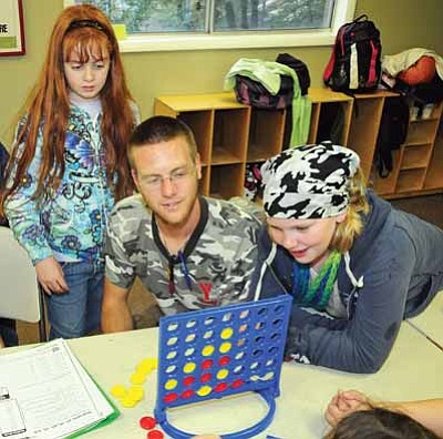 Brett Soldwedel/The Daily Courier<br>Audrey Lockling, 10, Mr. Josh Taylor, and Hannah Lackley, 10, play some Connect Four at the YMCA’s Lights on After School program in Prescott.