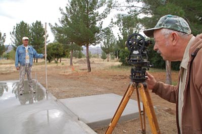 Bruce Colbert/The Daily Courier<br>
Dale Wilson, a retired surveyor and engineer, takes a final elevation check of the foundation at the future site of the Old Cañon School Museum at Heritage Park in Black Canyon City.