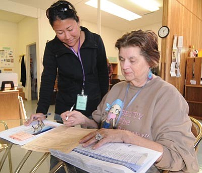 Les Stukenberg/The Daily Courier<br>Audra Yamamoto, a volunteer with Volunteer Income Tax Assistance (VITA) helps June Haynie of Dewey fill out paperwork before helping her with her tax documents for the 2011 tax season.