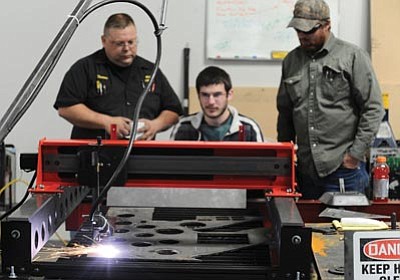 Les Stukenberg/The Daily Courier<br>Thomas Paulson, Tim Bellis (seated) and Grant Eckerman watch as they test out their new computer-driven cutter at Prescott Valley-based NEST Energy Services.